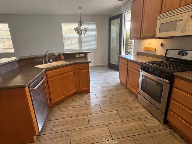 a kitchen with stainless steel appliances granite countertop a sink stove and cabinets