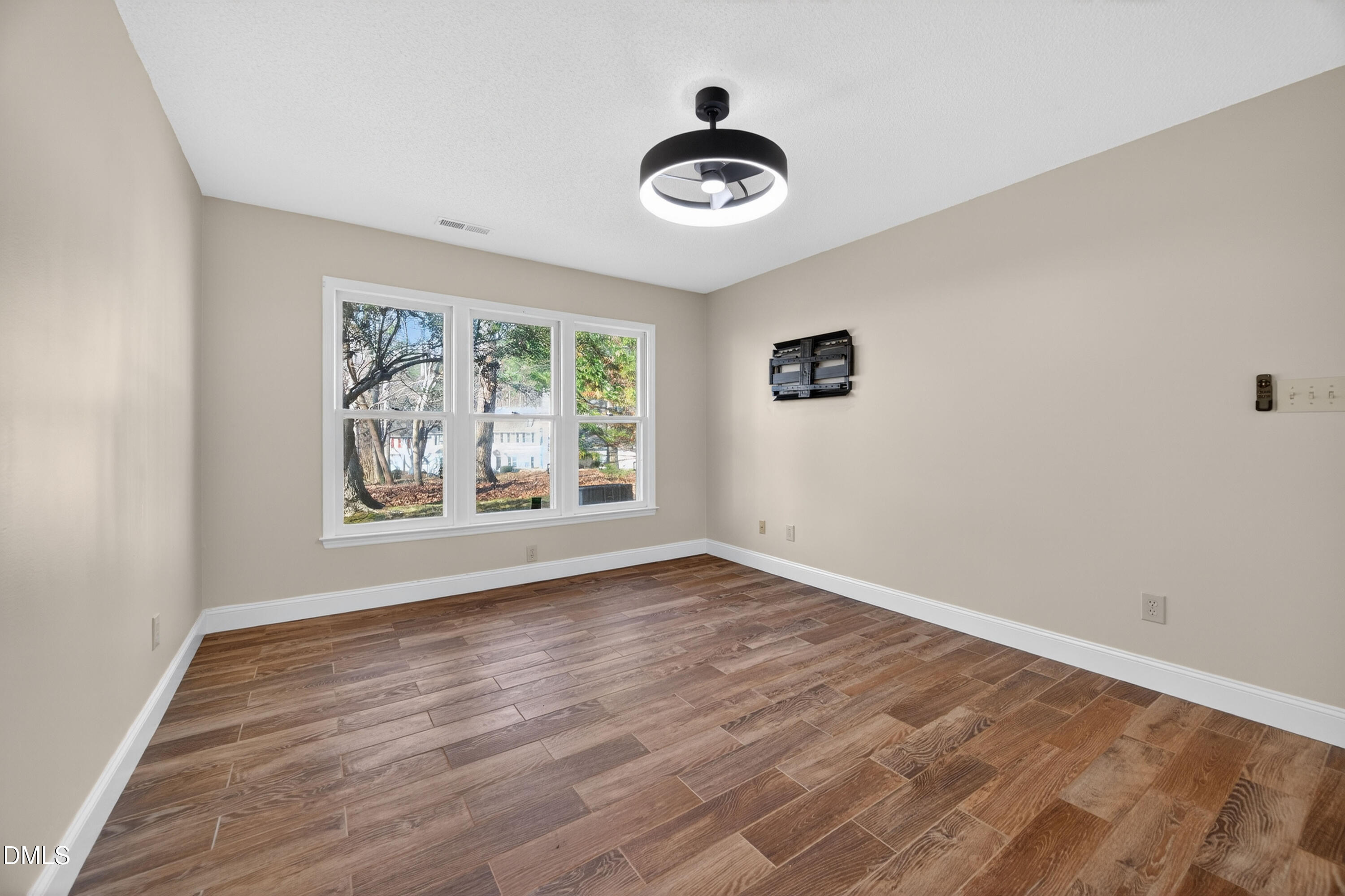 109 Linville River Road Cary, NC 27511 - Photo 22 of 41 a view of an empty room with a window and wooden floor