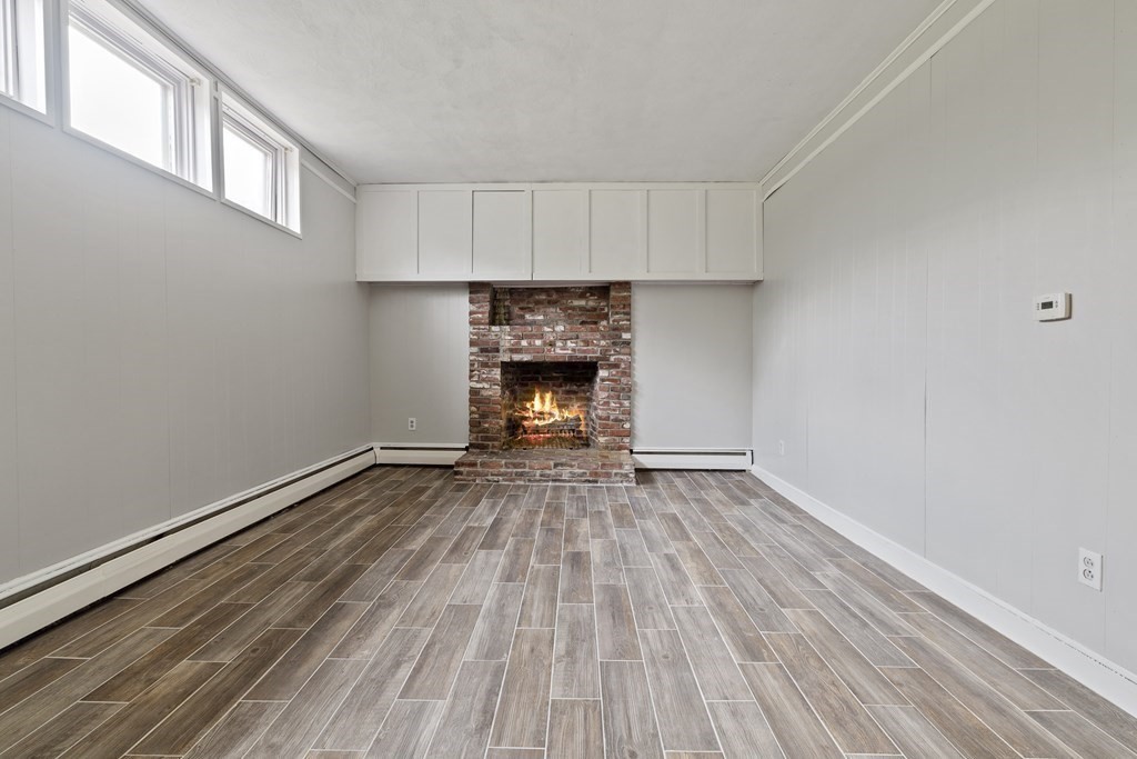 254 Edgell Road Framingham, MA 01701 - Photo 12 of 42 a view of an empty room with wooden floor fireplace and a window