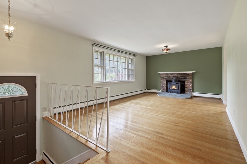 254 Edgell Road Framingham, MA 01701 - Photo 4 of 42 an empty room with wooden floor fireplace and windows