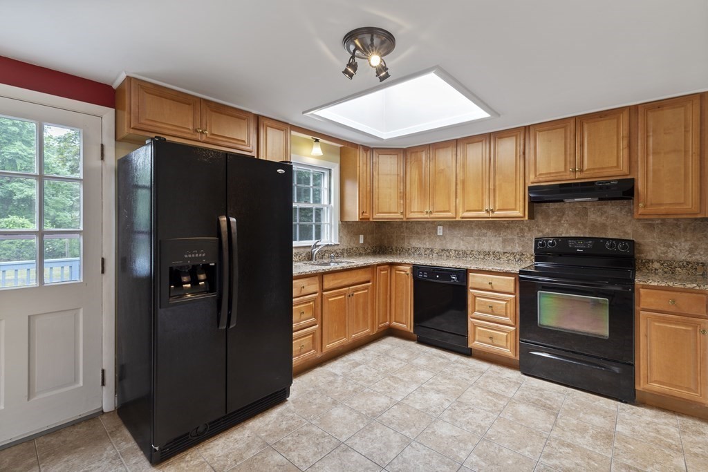 254 Edgell Road Framingham, MA 01701 - Photo 9 of 42 a kitchen with granite countertop a refrigerator and a stove top oven