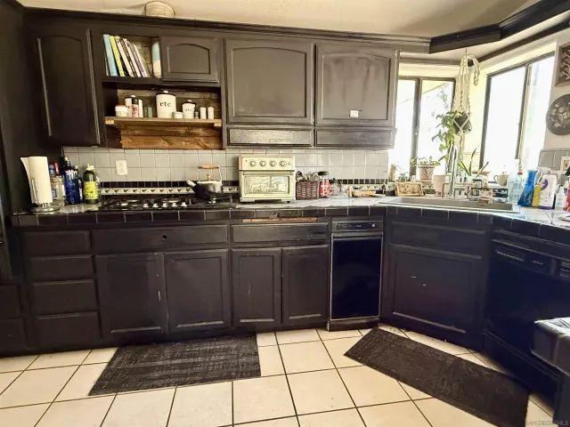 a kitchen with a sink window and cabinets