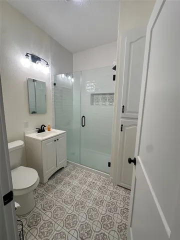 a bathroom with a sink a toilet a mirror and shower