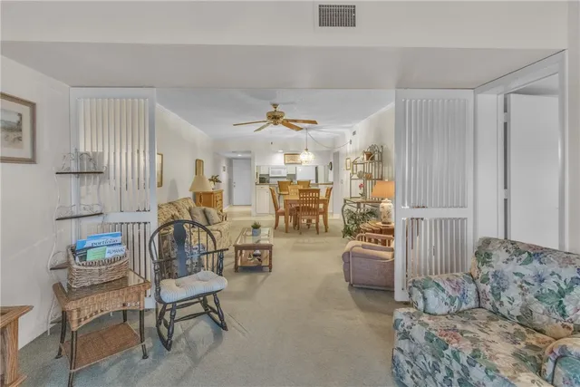 a living room with furniture and a view of kitchen