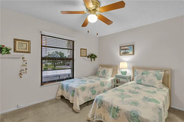 a bedroom with two beds and a large window