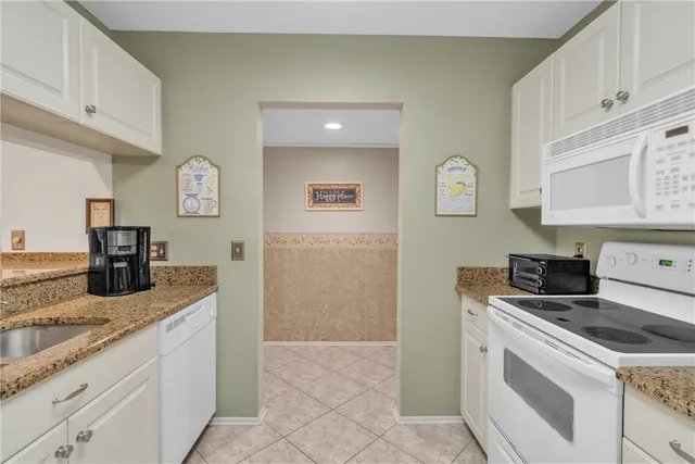 a kitchen with granite countertop a sink stove and refrigerator