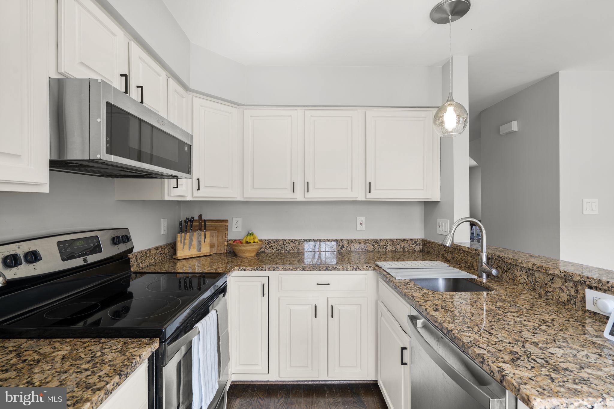 20250 Brookview Square Ashburn, VA 20147 - Photo 18 of 45 a kitchen with granite countertop a sink a stove and cabinets