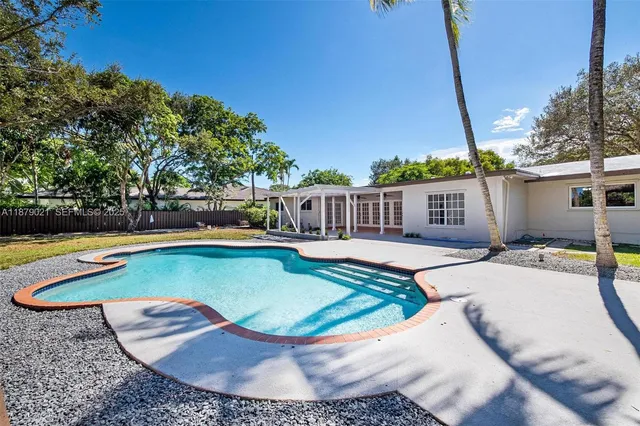 a patio with glass top table and chairs
