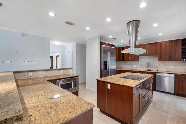 a kitchen with stainless steel appliances granite countertop wooden cabinets sink and stove