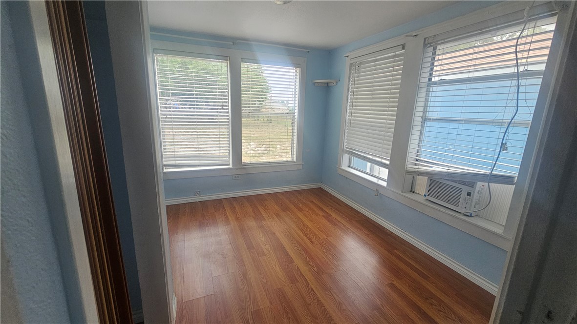 215 North Rife Street Aransas Pass, TX 78336 - Photo 8 of 11 a view of an empty room with wooden floor and a window