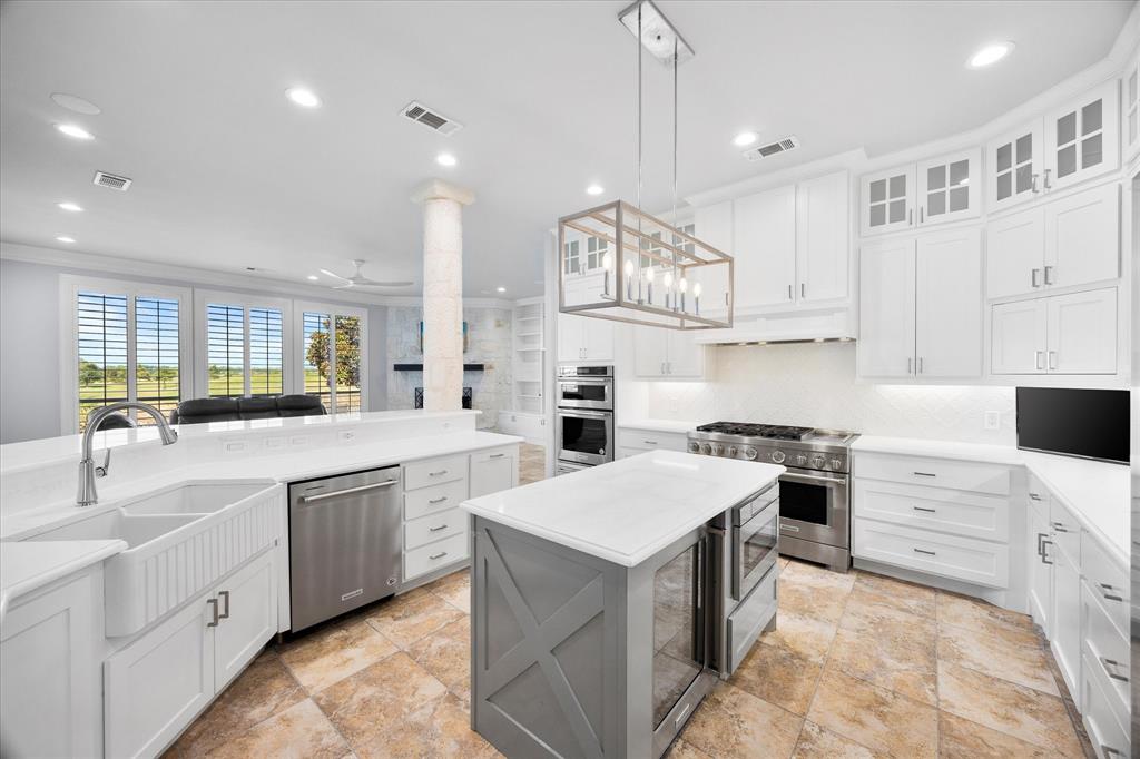 1572 Rabbit Rdg Road Heath, TX 75032 - Photo 17 of 36 a kitchen with kitchen island white cabinets and white appliances