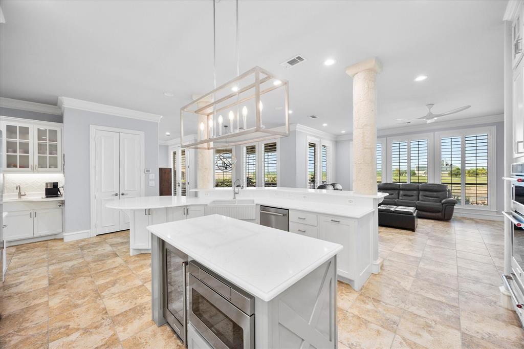 1572 Rabbit Rdg Road Heath, TX 75032 - Photo 19 of 36 a large white kitchen with kitchen island a sink a stove a dining table and chairs
