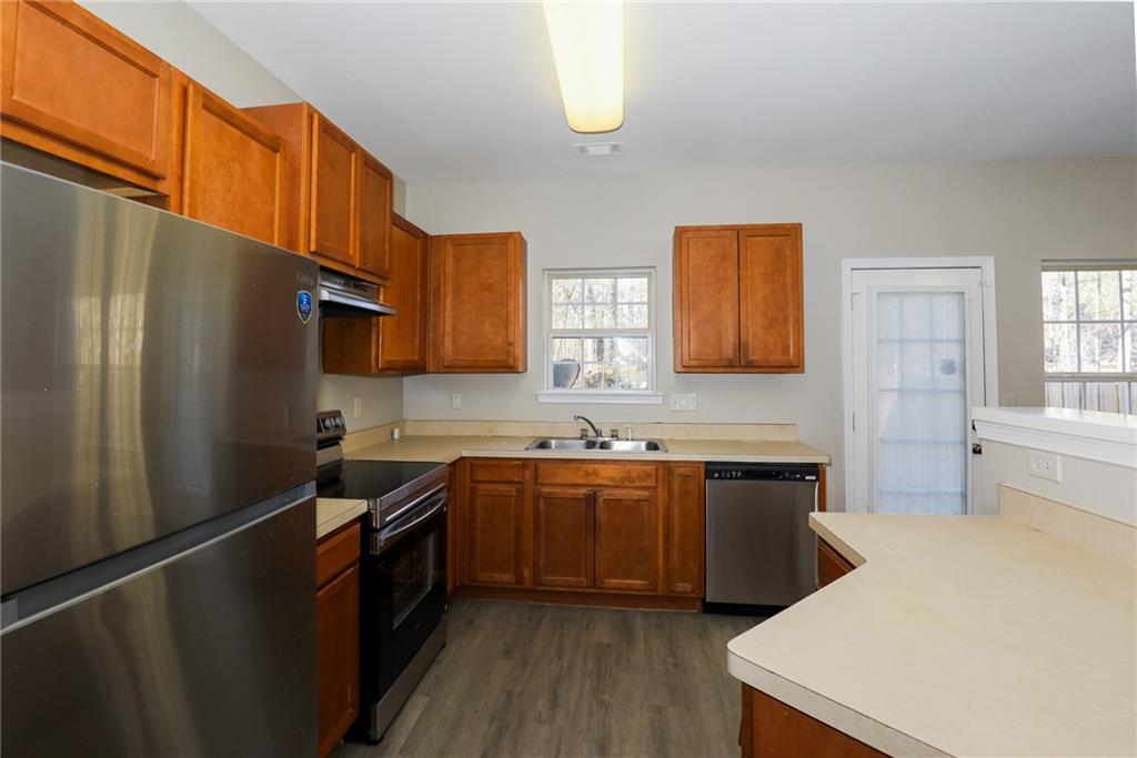 6926 Rogers Point Lithonia, GA 30058 - Photo 13 of 19 a kitchen with stainless steel appliances a sink stove refrigerator and cabinets
