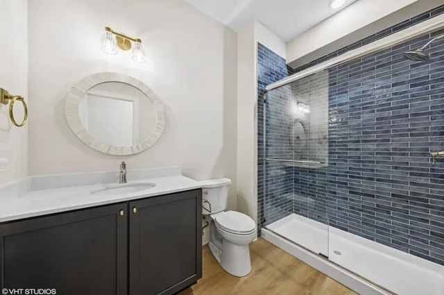 a bathroom with a sink a toilet and shower