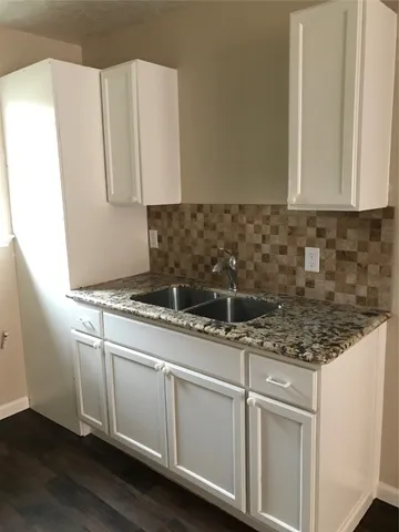 a kitchen with granite countertop a sink and a stove