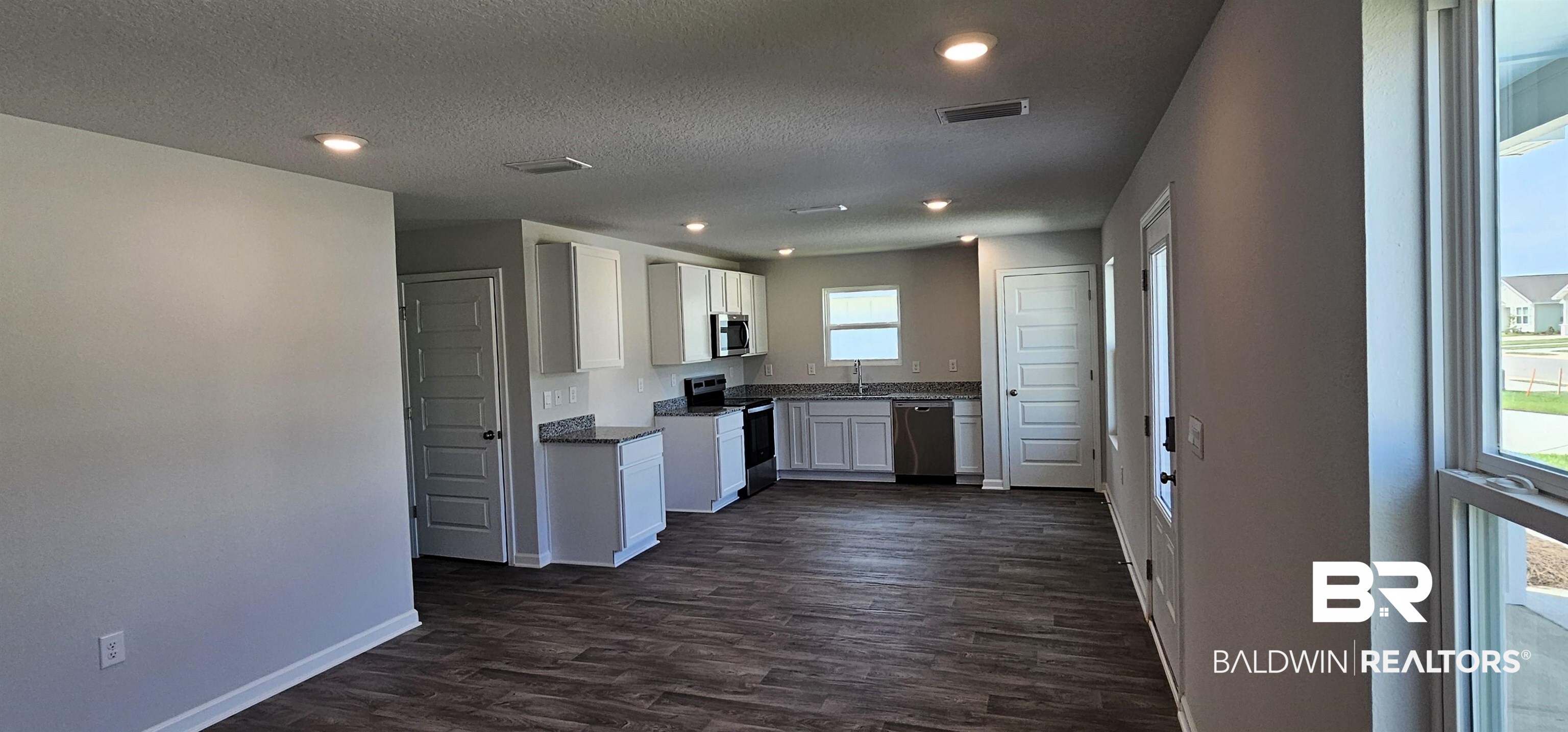 1144 Sweet Laurel Street Foley, AL 36535 - Photo 8 of 10 Kitchen with appliances with stainless steel finishes, dark hardwood / wood-style floors, sink, and white cabinetry