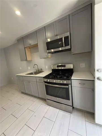 a kitchen with stainless steel appliances granite countertop a sink and a stove top oven
