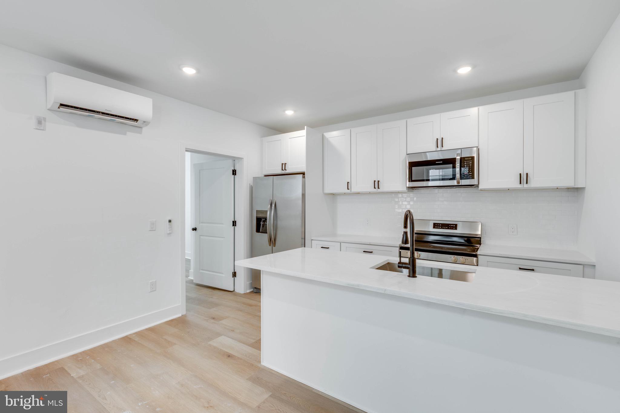 a kitchen with stainless steel appliances a refrigerator and a stove top oven