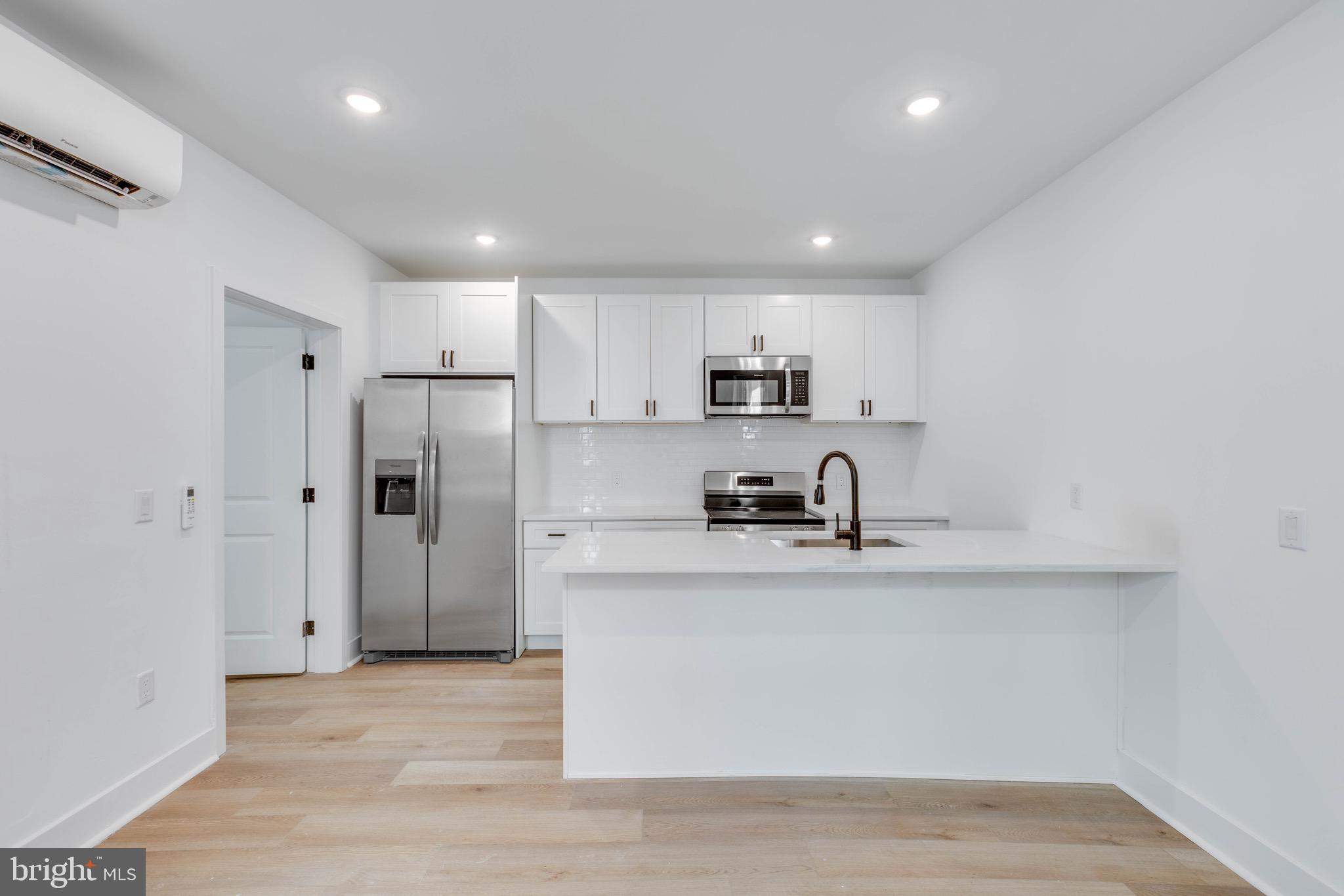 4220 Baltimore Avenue, Unit 2 Philadelphia, PA 19104 - Photo 2 of 11 a kitchen with stainless steel appliances a sink stove refrigerator and cabinets