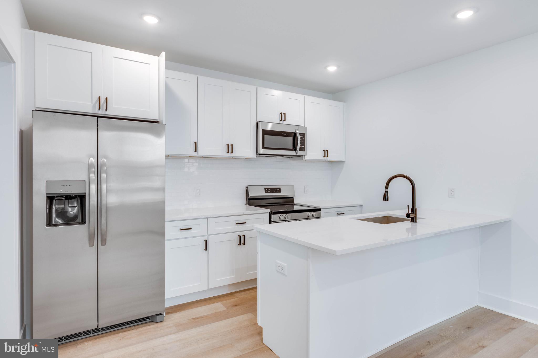 4220 Baltimore Avenue, Unit 2 Philadelphia, PA 19104 - Photo 4 of 11 a kitchen with stainless steel appliances granite countertop a refrigerator sink and white cabinets
