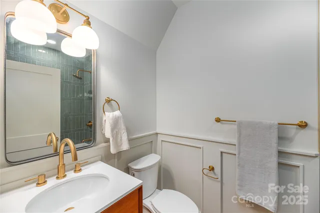 a bathroom with a sink a toilet and a mirror