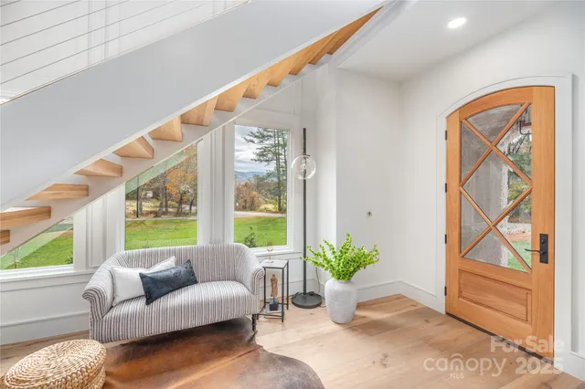 a living room with furniture and a large window with garden view