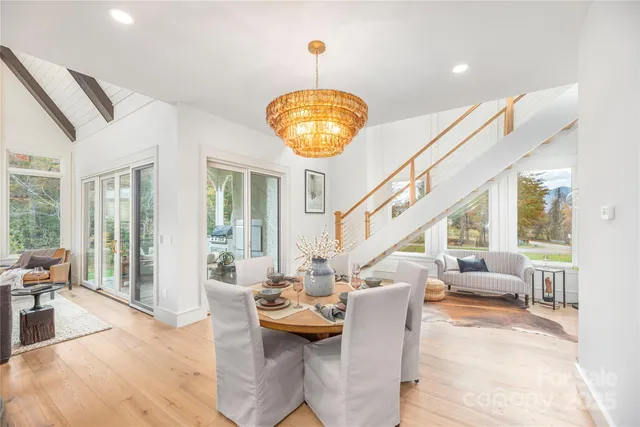 a living room with furniture a chandelier and a large window