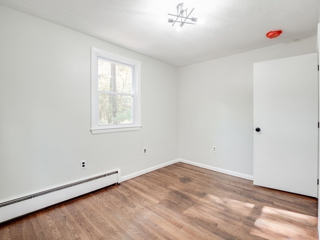 116 Arkansas Road Tewksbury, MA 01876 - Photo 18 of 38 a view of an empty room with wooden floor and a window