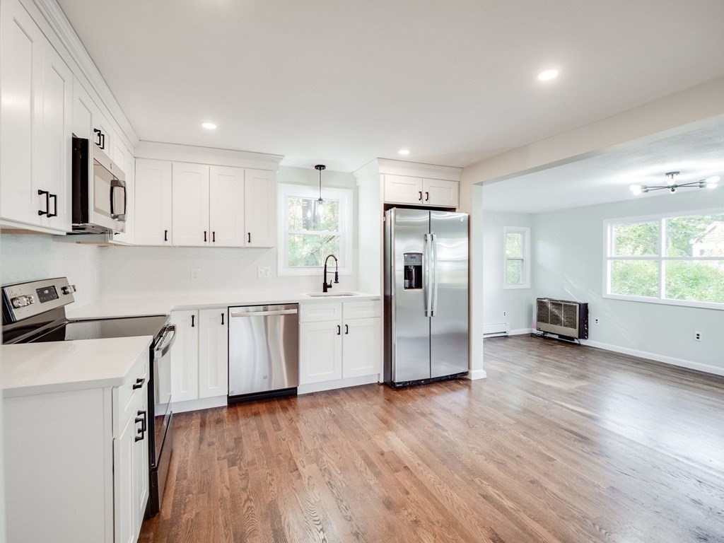 116 Arkansas Road Tewksbury, MA 01876 - Photo 5 of 38 a kitchen with white cabinets and wooden floor