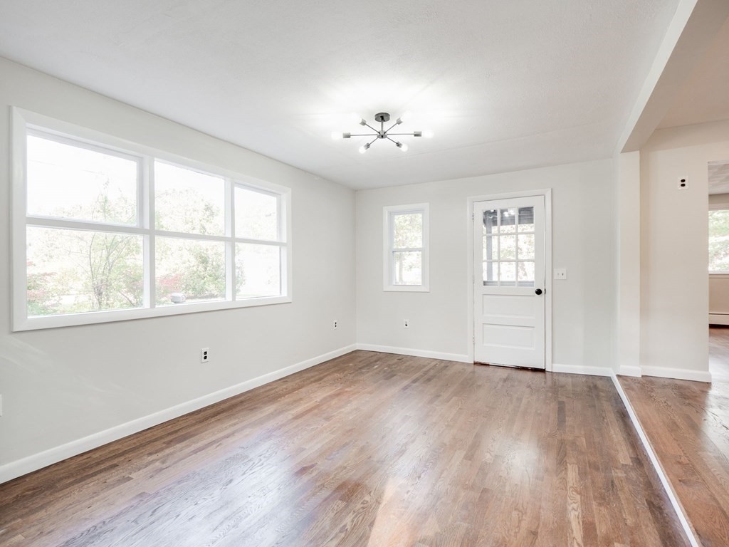 116 Arkansas Road Tewksbury, MA 01876 - Photo 9 of 38 an empty room with wooden floor and windows