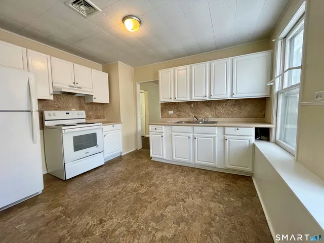 a kitchen with white cabinets and white appliances