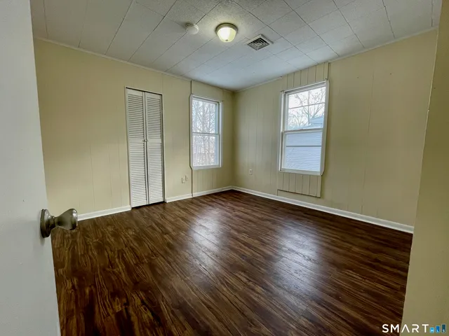 a view of a livingroom with wooden floor and a window