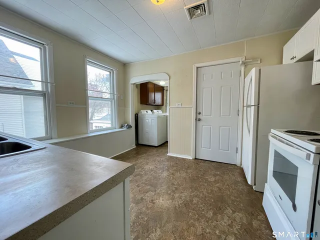 a view of a kitchen with flat screen tv and refrigerator