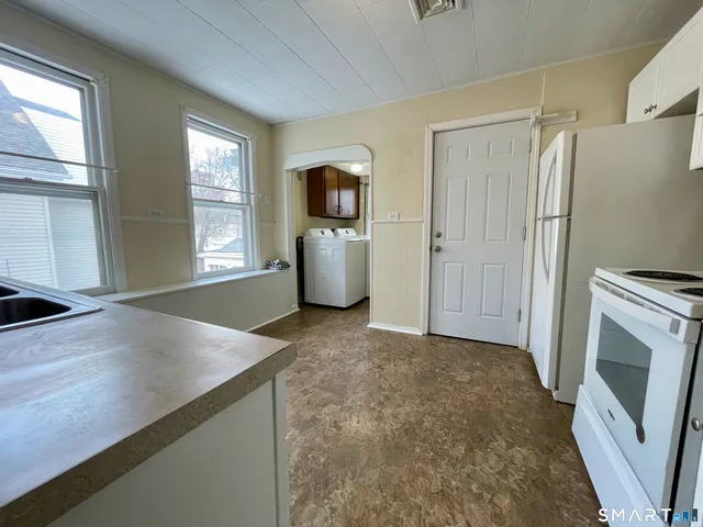 a view of kitchen with windows and refrigerator