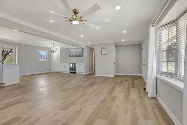 a view of an empty room with window and wooden floor