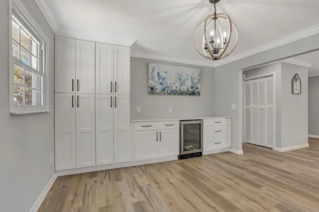 a view of a bedroom with wooden floor and window