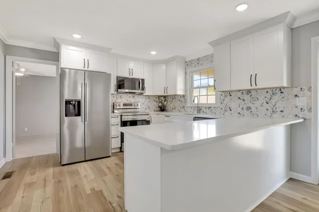 a kitchen with stainless steel appliances a refrigerator sink and microwave