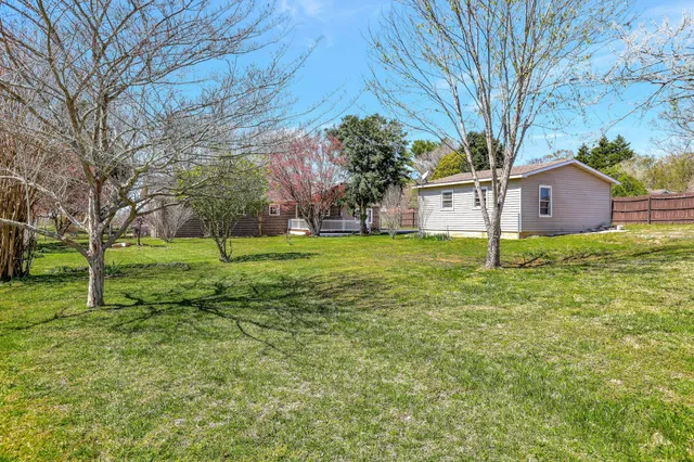 a view of a house with backyard and a tree