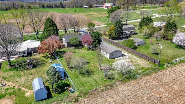an aerial view of a house with a garden and lake view
