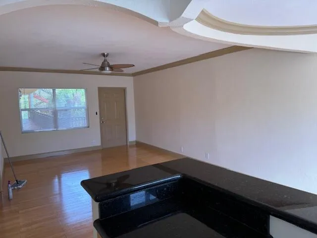 a view of a living room with kitchen view and wooden floor