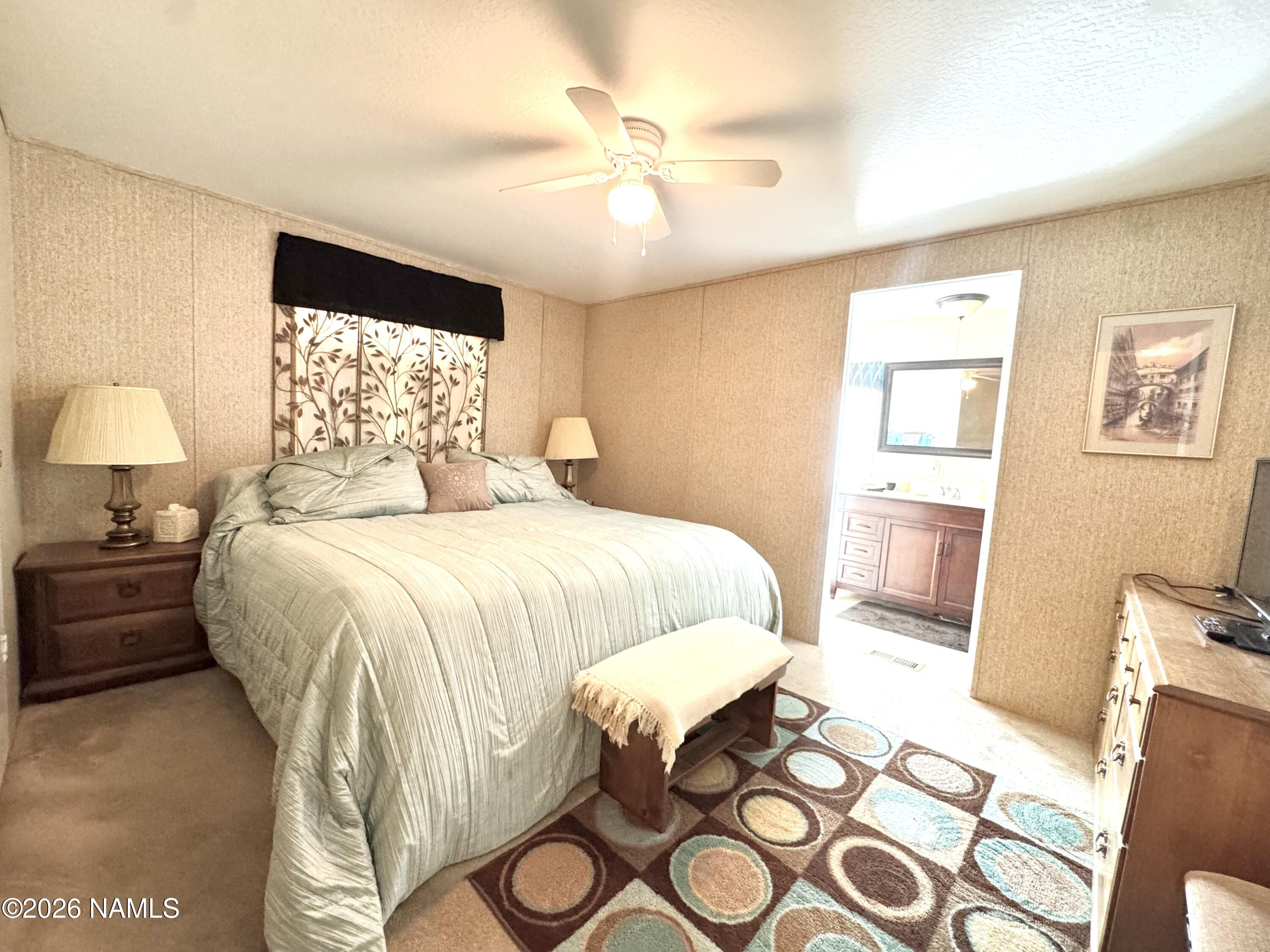 45 Fairlane Road Munds Park, AZ 86017 - Photo 13 of 24 a bedroom with a bed and wooden floor