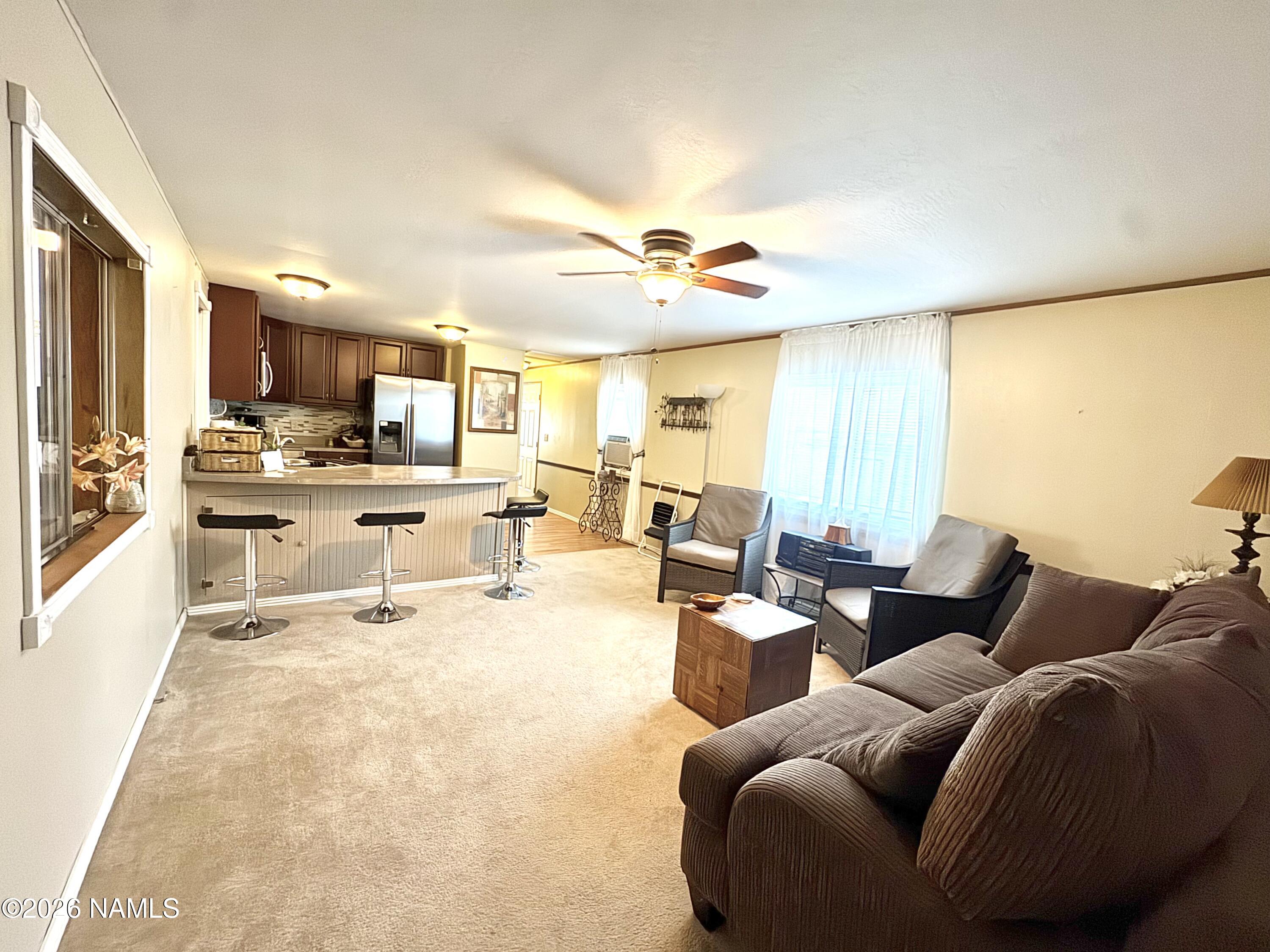 45 Fairlane Road Munds Park, AZ 86017 - Photo 8 of 24 a living room with furniture and a large window with kitchen view