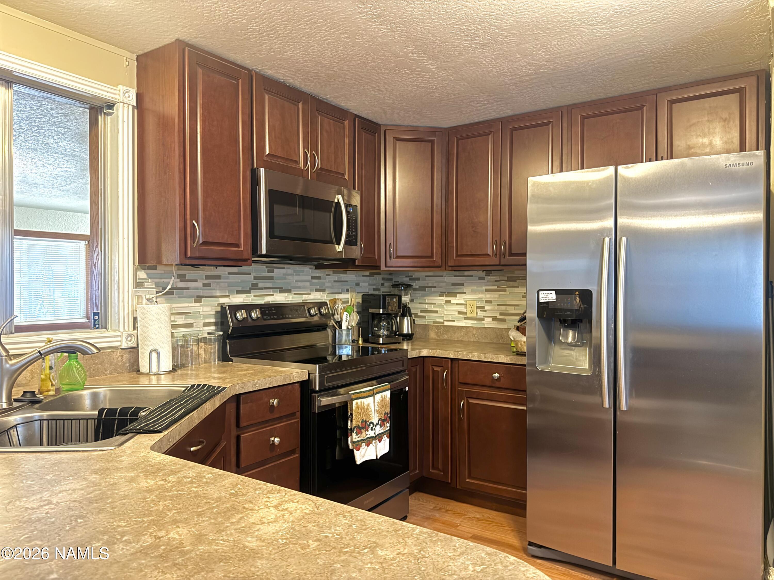 45 Fairlane Road Munds Park, AZ 86017 - Photo 10 of 24 a kitchen with granite countertop stainless steel appliances and wooden cabinets