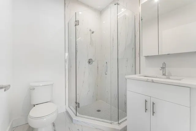 a bathroom with a shower a toilet and sink