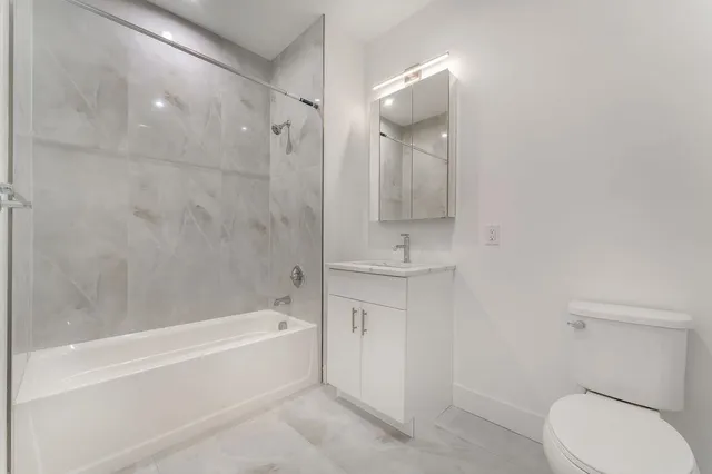 a spacious bathroom with a sink a toilet and a bathtub