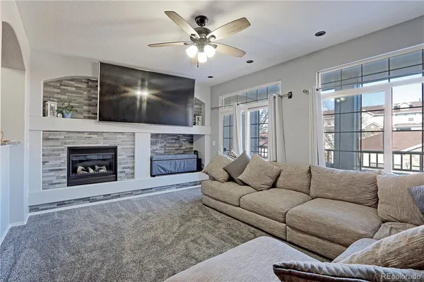 a living room with furniture a flat screen tv and a fireplace