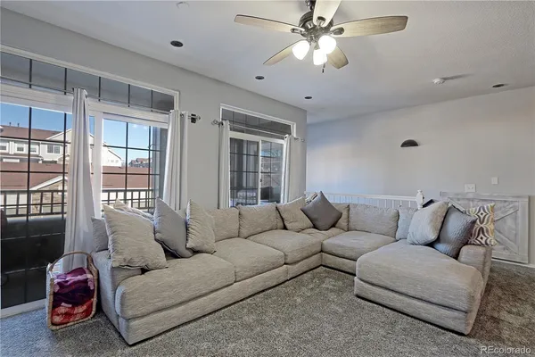 a living room with furniture ceiling fan and a window