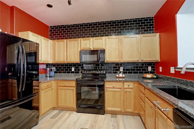 a kitchen with a sink a stove and cabinets
