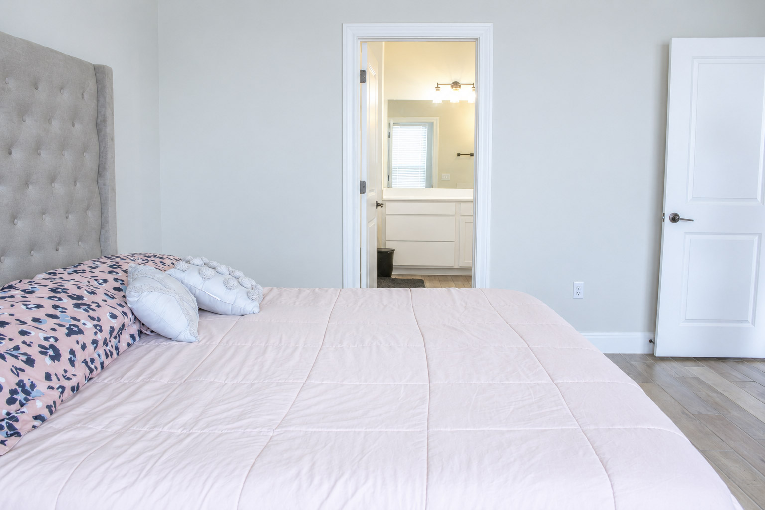 181 Tree Nut Loop Buda, TX 78610 - Photo 20 of 33 Smooth wood floors anchor this comfortable bedroom featuring an attached private bathroom.