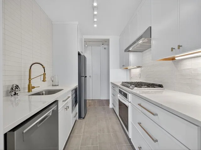 a kitchen with stainless steel appliances granite countertop a sink stove and refrigerator